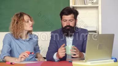老师在教室里情侣。 快乐的休闲女学生，留着胡子的时髦老师在黑板背景上